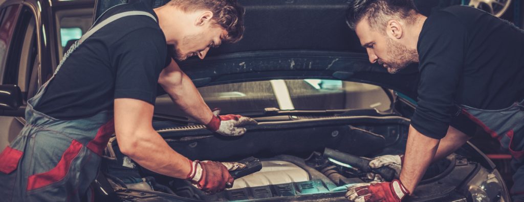 Two mechanics looking over a car with its bonnet open - Car Servicing Worthing